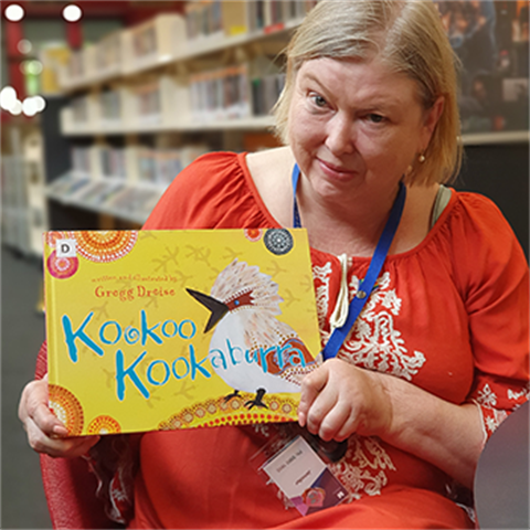 photo of youth librarian Jennifer holding a picture book