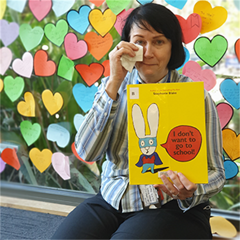 Youth librarian Lilian holding a picture book