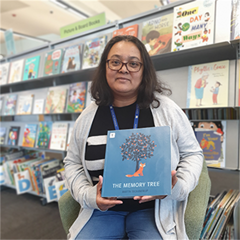 Youth librarian Wendy holding a picture book