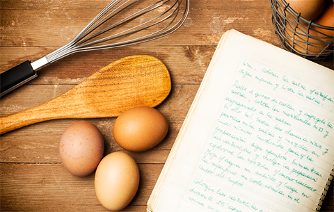 photo of eggs and cooking utensils next to a recipe book