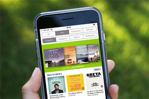 a person holding a phone with the BorrowBox app open