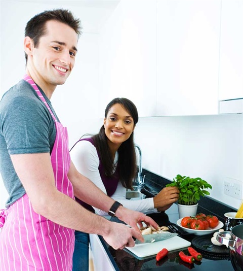 Young male and female couple cooking dinner