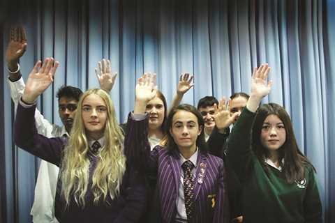Group of young people raising their hands