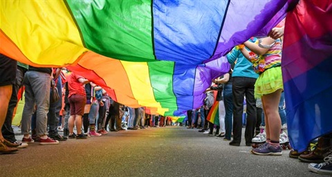 People holding up the Gay Pride flag