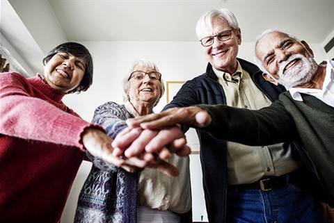 A Group of Seniors Huddled Together With Hands In.jpg