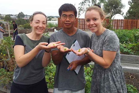 Monash Permaculture Group holding out seeds for the camera