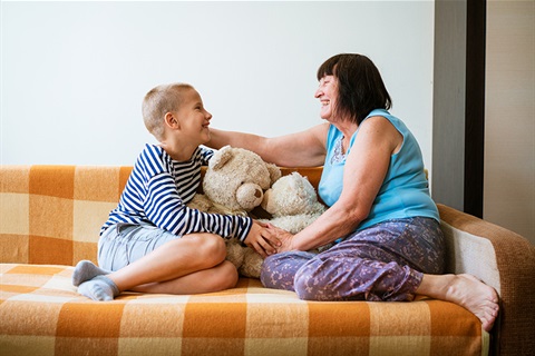 Child and grandmother playing with teddies